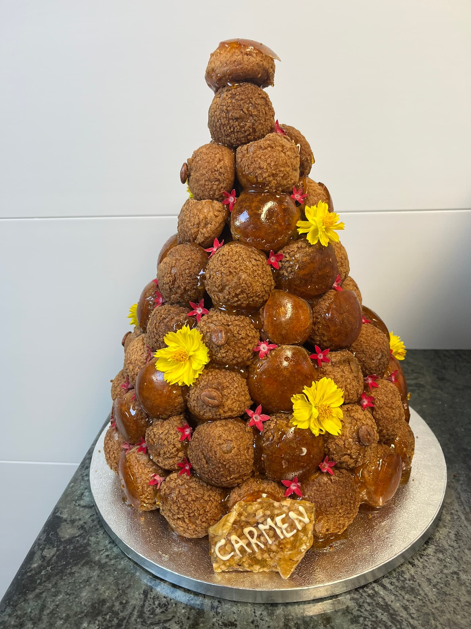 Croquembouche pièce montée traditionnelle Croquembouche pièce montée de choux caramélisés avec nougatine et fleurs fraîches, Montauban